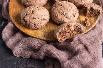 Delicious chocolate cookies with nuts on dark old concrete table. Copy space.