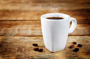 Cup of hot strong coffee with coffee beans