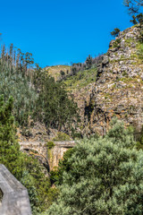 View of mountains and a old roman bridge over Paiva river, in stone, with vegetation around