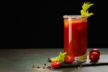 Bloody Mary cocktail. Alcoholic drink and ingredients on dark green background, Copy space