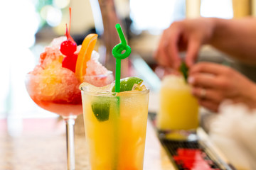 ice cold glass cocktails with blurred background of bartender hand