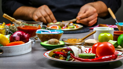 Close up of a chef hands preparing Taco. Cook preparing delicious Taco at kitchen. The concept of mexican cooking recipe