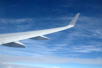 Beautiful top view of large white cumulus from passenger supersonic airplane window moving high from right to left high in the blue sky