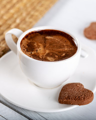 cup of coffee and cookies on white table