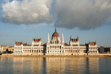 Hungarian parliament in Budapest under two big clouds. Frontal view