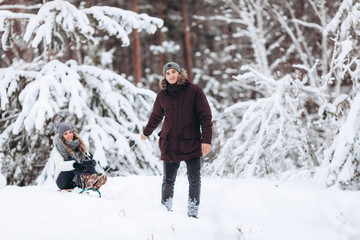 Fototapeta na wymiar Beautiful couple on sledge having fun, winter snow day