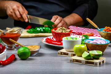 Fast food cooking. Hands preparing tortilla wrap with cuts meat and vegetable salad, mexican burito