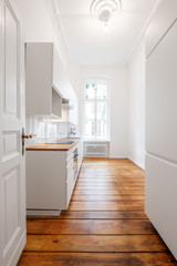 new white kitchenette / kitchen in renovated old building with wooden floor