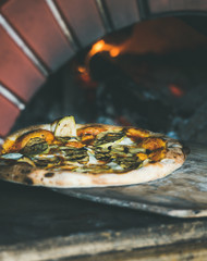 Freshly baked pizza with cheese and mushrooms in pizza oven
