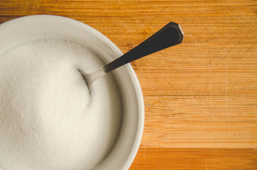 Sugar bowl with a spoon placed on a wooden table