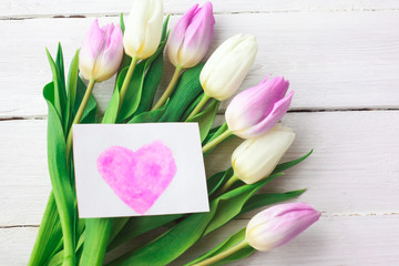 White and purple tulips on a white wooden background. Spring. International Women's Day. Valentine's Day. card with watercolor hearts,Selective focus.