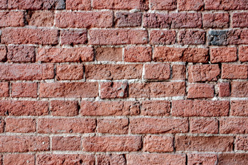Fragment of the old brickwork close-up. Potholes and defects of red bricks.