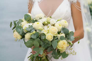bride holds a luxurious white wedding bouquet