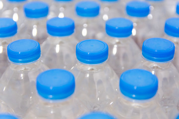 Row of water bottles. Bottles with blue caps For drinking water