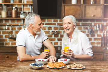 couple laughing together while having breakfast