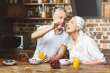 man feeding woman with cherries