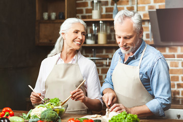 couple cutting vegetables for salad