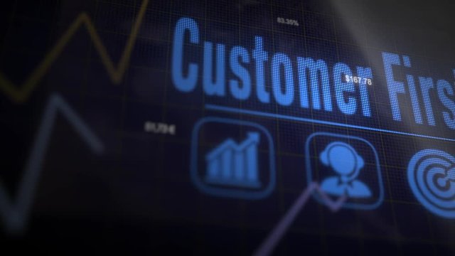 Customer First business concept on a flashing computer monitor with moving graphs and data.