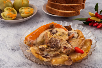 Baked potatoes with mushrooms and meat. Slice of pumpkin with hot pepper. Marinated green tomatoes with carrots. Sliced bread. Light background. Delicious and nutritious dinner.