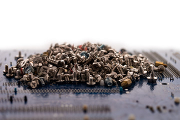 Bolts and screws for computer repair on the electronic board. White background. Selective focus. Close-up.