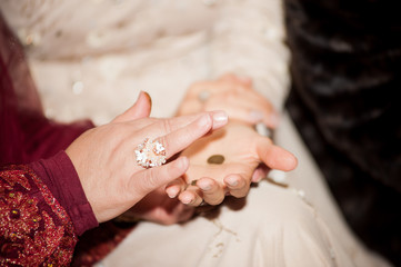 Woman's hand paints henna for the bride in arab henna night, engagement
