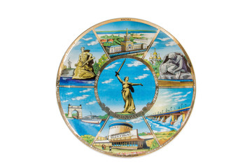 ceramic souvenir toy in the form of plate with color painting on isolated white background reflecting the national Russian culture with the inscription in Russian: the name of the city of Volgograd