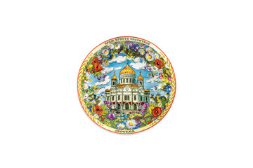 Fototapeta na wymiar ceramic souvenir toy in the form of plate with color painting on isolated white background reflecting the national Russian culture with the inscription in Russian: Cathedral of Christ Savior of Moscow