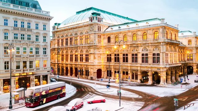 Vienna, Austria. View of State Opera in Vienna, Austria during the snowy evening in winter. Cloudy sky, time-lapse with car traffic, zoom in