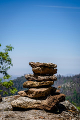 Aufeinander gestapelte Steine mit Bergen und Himmel im Hintergrund