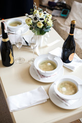 Ceramic tableware on the table and and two bottles of champagne