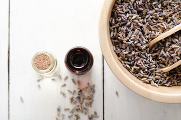 Bowl of Lavender Buds with Glass Oil Vials on White Wood Planked Table From Above