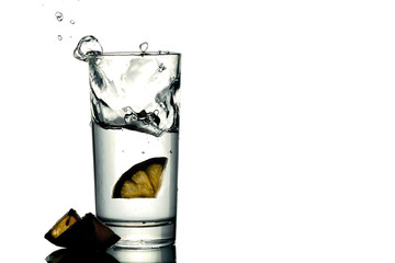 slices of lemons fell in a glass with water isolated on white