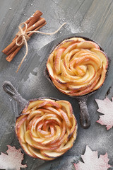 Homemade puff pastry with rose shaped apple slices baked in iron skillet