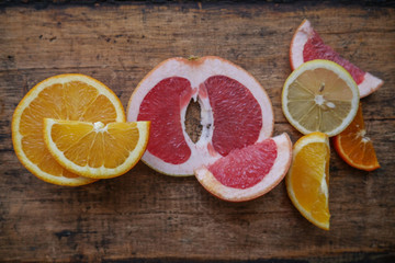 Fresh citrus fruits half cut on wooden background