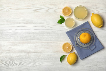 Flat lay composition with freshly squeezed lemon juice and space for text on wooden background