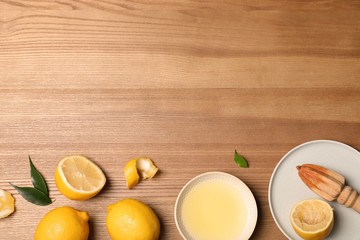 Flat lay composition with freshly squeezed lemon juice and space for text on wooden background