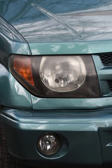 Fototapeta premium shiny headlights on a green car