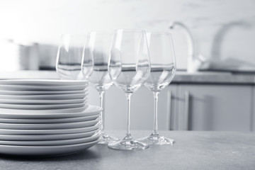 Set of clean dishes on table in kitchen. Space for text