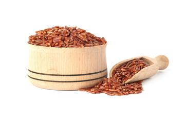 Bowl and scoop with uncooked brown rice on white background