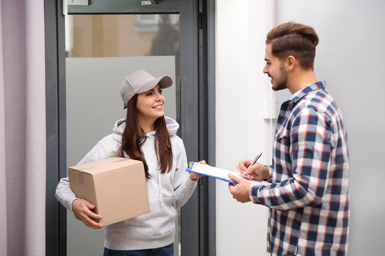 Man receiving parcel from delivery service courier indoors