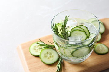 Glass of fresh cucumber water on table. Space for text