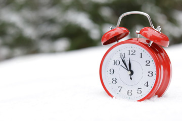Red alarm clock on white snow outdoors. Space for text