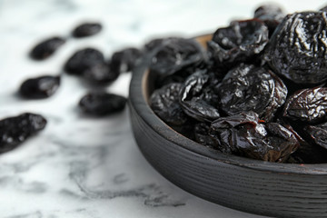Plate of sweet dried plums on table, closeup with space for text. Healthy fruit