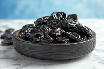 Plate of sweet dried plums on table, closeup. Healthy fruit