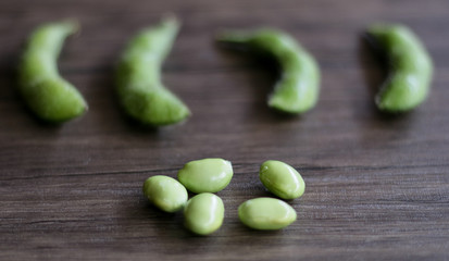 Young soy beans or edamame on wood background.