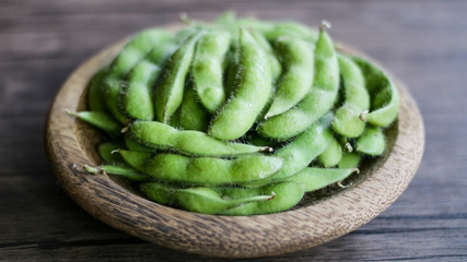 Young soy beans or edamame on wood background.