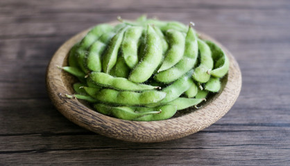 Young soy beans or edamame on wood background.