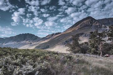 Beautiful scenery of british countryside.Mountain peak painted with natural light in scenic valley and blue sky with few clouds above.