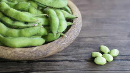 Young soy beans or edamame on wood background.