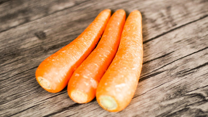Fresh carrots on wood background.